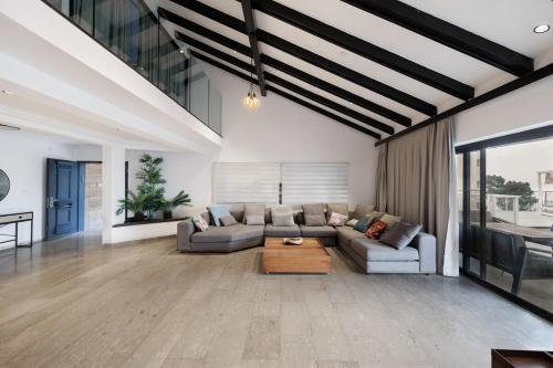 提比里亚וילה רז של רשת לב הגולן - וילה מדהימה עם בריכה פרטית מחוממת וסאונה的客厅里有一张沙发和一张桌子。