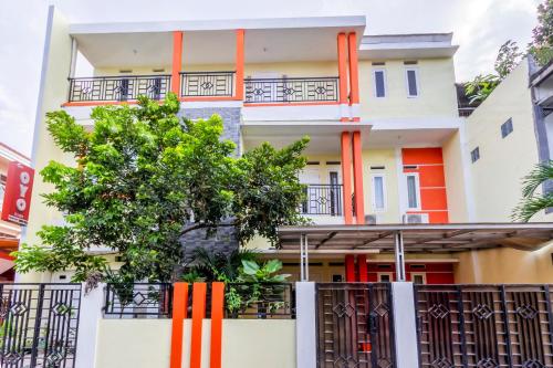 an apartment building with orange pillars at Hotel O Yogyakarta near Universitas Gadjah Mada formerly Sellinas Guesthouse in Yogyakarta