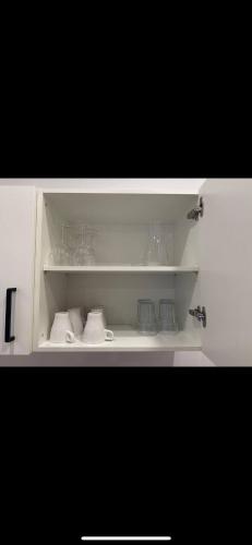 a white cabinet filled with glasses and other items at an der Elbe in Freiburg - Elbe