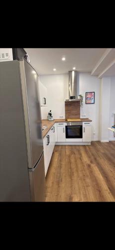 a kitchen with a stainless steel refrigerator and wooden floors at an der Elbe in Freiburg - Elbe