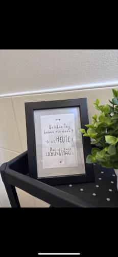 a picture in a frame on a table with a plant at an der Elbe in Freiburg - Elbe