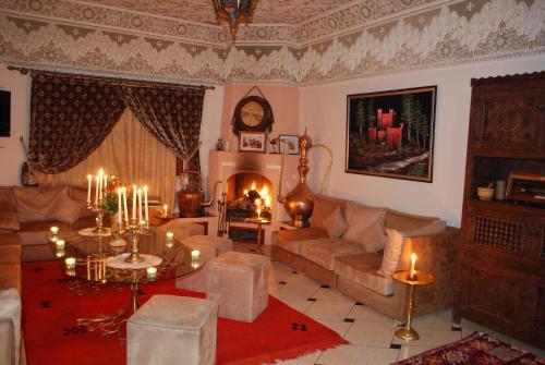a living room with a couch and a fireplace at Riad Villa Midelt in Midelt
