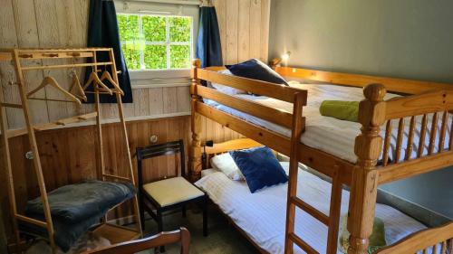 a bedroom with two bunk beds and a chair at Les Gites de la Renardière in Gueures