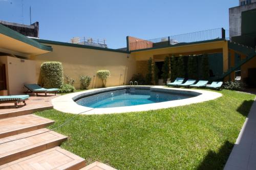 a backyard with a swimming pool in the grass at Corrientes Plaza Hotel in Corrientes