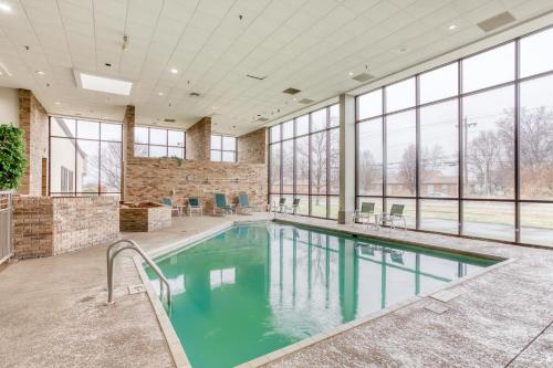 a swimming pool in a large room with windows at OYO Townhouse Owensboro West in Owensboro