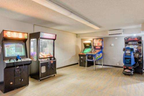 a room with two arcade games and two video games at OYO Townhouse Owensboro West in Owensboro