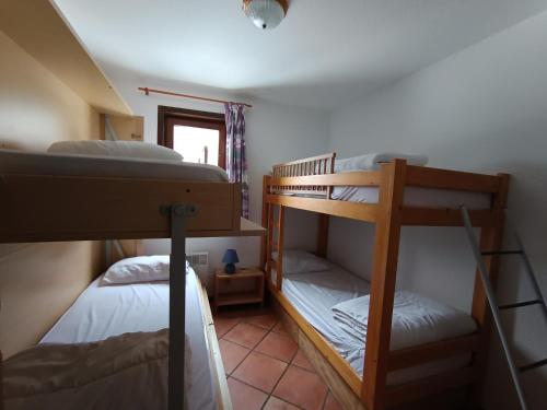 une chambre avec deux lits superposés et une fenêtre dans l'établissement Appartement 3 pièces - 8 pers - 100m des pistes - Animaux & Parking inclus - FR-1-445-110, à Montgenèvre