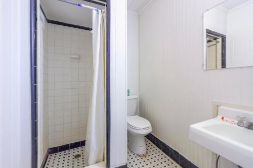 a white bathroom with a toilet and a sink at OYO Hotel Brookhaven MS Hwy 51 North in Brookhaven
