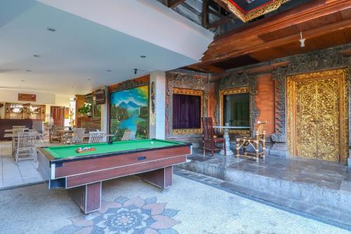 a pool table in the middle of a room at Capital O 1666 Grand Pudjawan Hotel Near Kuta Beach in Kuta