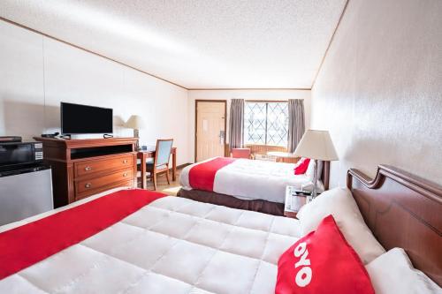 a hotel room with two beds and a television at OYO Hotel Windmill Branson in Branson