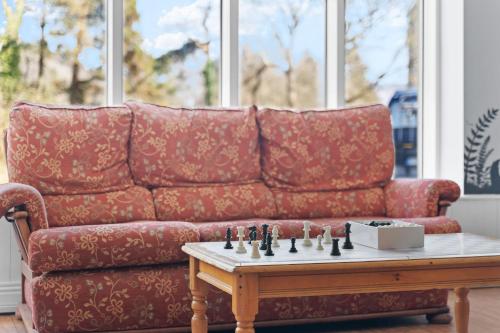 a red couch with a chess board on a coffee table at Glendalough International Youth Hostel in Laragh