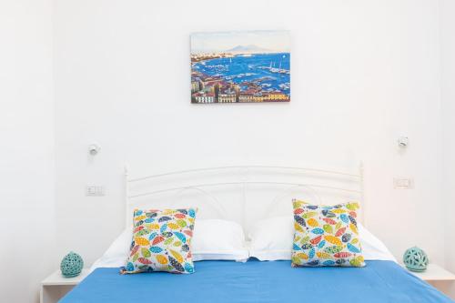 a bedroom with a bed with blue sheets and pillows at Estate4home - Casa Satriano in Positano