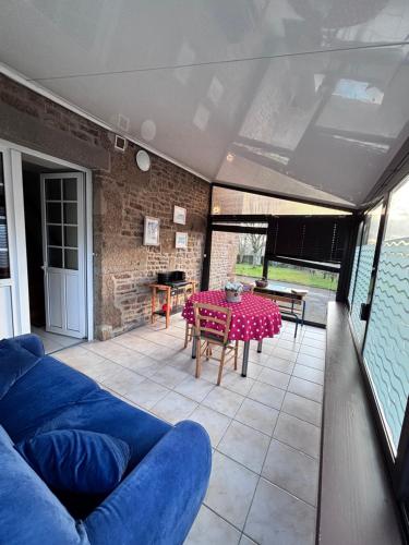 un salon avec un canapé bleu et une table dans l'établissement GITE de la Giraudais, à Saint-Mars-sur-la-Futaie