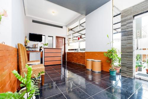 an office with a lobby with plants and a tv at Hotel O Solo Point Guest House Syariah in Solo