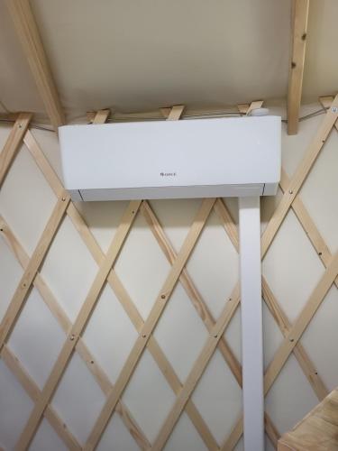a white stove in a room with a ceiling at Yourte de déconnexion chauffage climatisation in Briollay