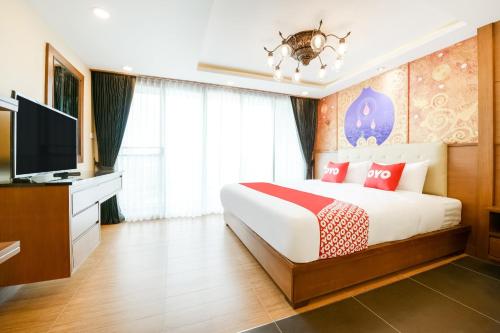 a bedroom with a bed and a flat screen tv at OYO 458 Nakorn Siam Boutique in Pattaya