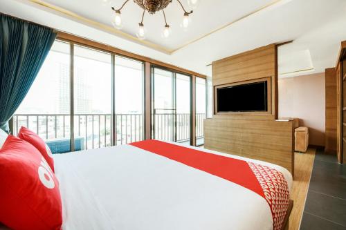 a bedroom with a large bed and a television at OYO 458 Nakorn Siam Boutique in Pattaya