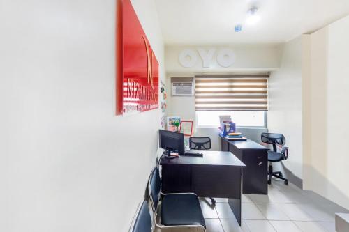 an office with a desk with two computers and chairs at OYO 474 Nizami Condotel in Manila