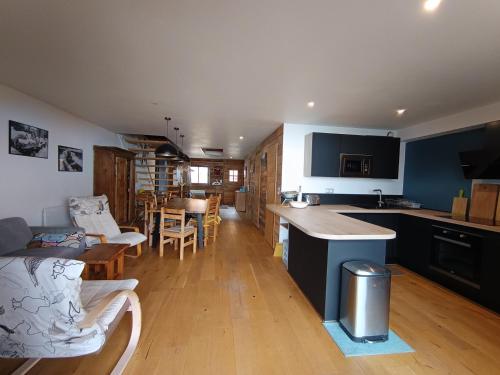 une cuisine et un salon avec une table et des chaises dans l'établissement Chalet luxe refait à neuf, 50m des pistes, garage, terrasse, 125m², 8 pers, animaux acceptés - FR-1-445-192, à Montgenèvre