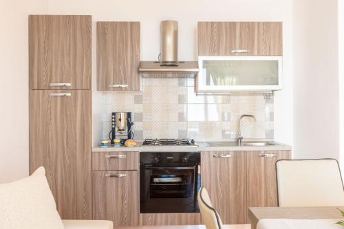 a kitchen with wooden cabinets and a sink and a stove at Estate4home - Casa Satriano in Positano