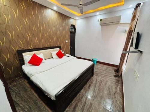 a bedroom with a bed with two red pillows at Prayag Villa Inn in Allahābād