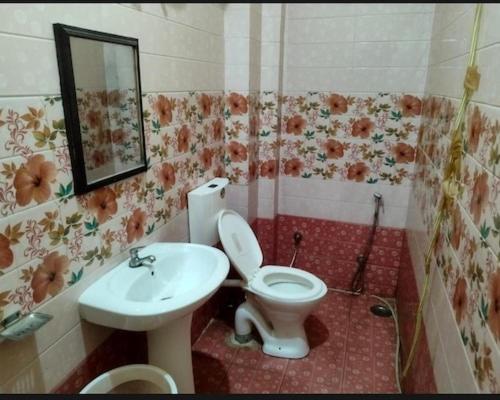 a bathroom with a toilet and a sink at Prayag Villa Inn in Allahābād