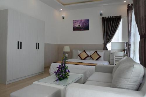 a white living room with a couch and a bed at Godiva Villa Phu Quoc in Phu Quoc