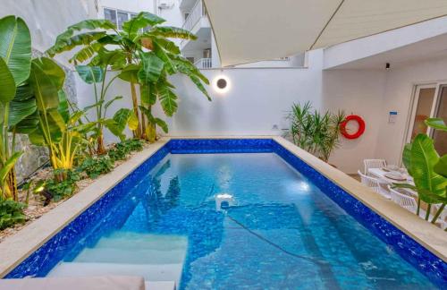 a swimming pool in a room with plants at Luxury Apartment in St Pauls Bay w pool by Homely in St. Paul's Bay