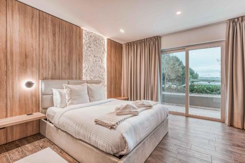 a bedroom with a large bed and a large window at Luxury Apartment in St Pauls Bay w pool by Homely in St. Paul's Bay
