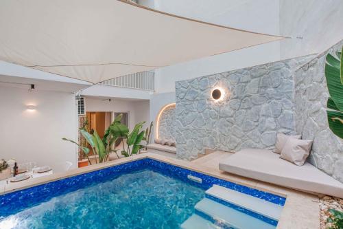 a pool in a house with a stone wall at Luxury Apartment in St Pauls Bay w pool by Homely in St. Paul's Bay