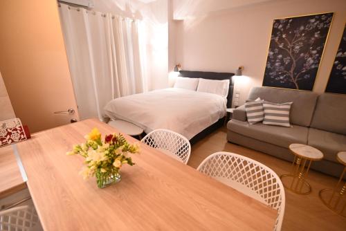 a hotel room with a bed and a table with flowers on it at Lilaki in Larisa