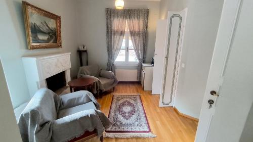 a living room with two chairs and a fireplace at Venetula's Rooms - Limoza in Kastoria