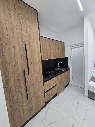 a kitchen with wooden cabinets and a sink at Elite Inn in Vlorë
