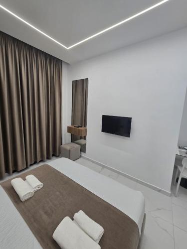 a bedroom with a large bed with two white pillows at Elite Inn in Vlorë