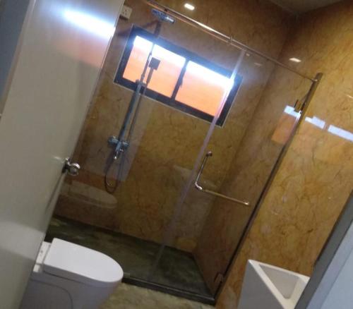 a bathroom with a glass shower with a toilet at Kitty cointainer bungalow ambewela - kcb ambewela in Nuwara Eliya