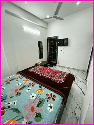 马图拉HOTEL PREMIUM SHRI PRABHU DHAM Near Temple VRINDAVAN的卧室里有一张床，床上铺着一条花毯子