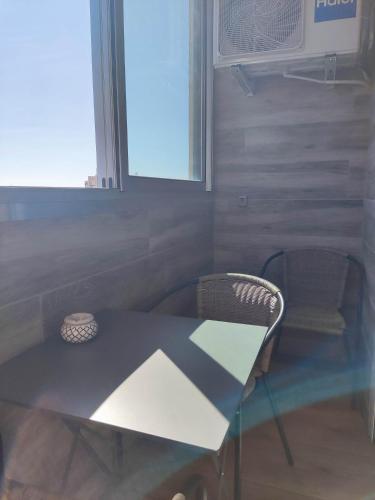 une table et des chaises dans une pièce avec une fenêtre dans l'établissement Les Lavandes, parfait pour le Thermalisme, à Balaruc-les-Bains