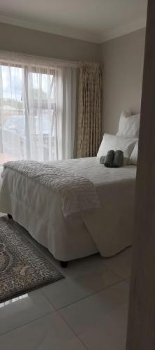 a white bed in a bedroom with a window at Ee40Yethu in Pretoria