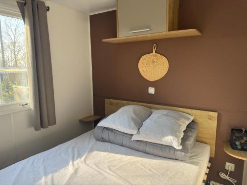 een slaapkamer met een bed met witte lakens en kussens bij Ô Coeur d'Eden ,2 mobilhomes l'Ôriginal et le BÔ'Aime in Piriac-sur-Mer