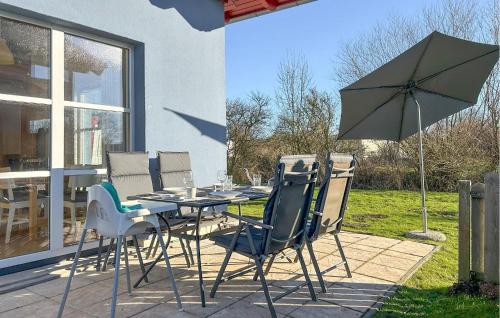 a table and chairs and an umbrella on a patio at Seebrise in Süssau