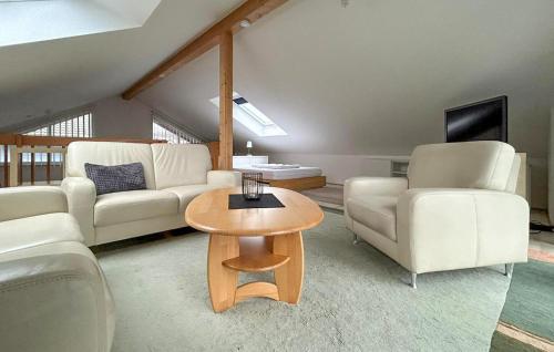 a living room with white furniture and a table at Seebrise in Süssau