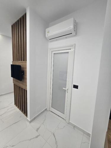a white room with a door and a heater at Elite Inn in Vlorë