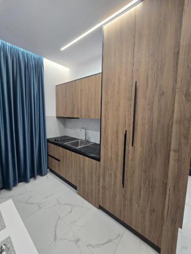 a kitchen with wooden cabinets and a sink at Elite Inn in Vlorë