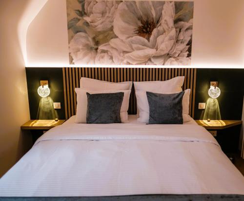a bedroom with a large white bed with two lamps at Appartement Design Centre Résidence Historique avec Parking in Amiens