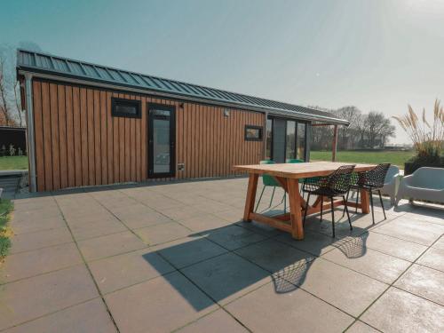 a patio with a table and chairs and a building at Nieuwe Luxe Lodge met Weidezicht - bij Nationaal park Drents-Friese Wold in Hoogersmilde
