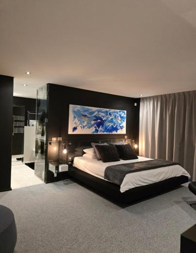a bedroom with a large bed with a painting above it at Luxury Penthouse with Private Pool in Cape Town