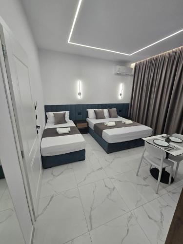 a hotel room with two beds and a table at Elite Inn in Vlorë