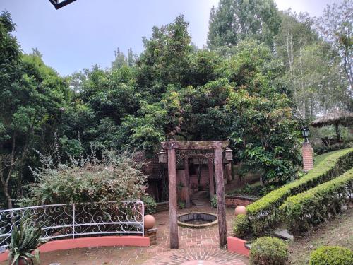 a garden with a gate and a bench at Pousada dos Pássaros in Santo Antônio do Pinhal