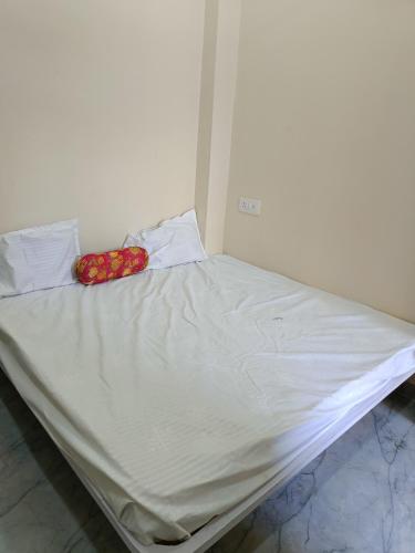 a large bed with white sheets and flowers on it at hotel shree shivganga in Ujjain