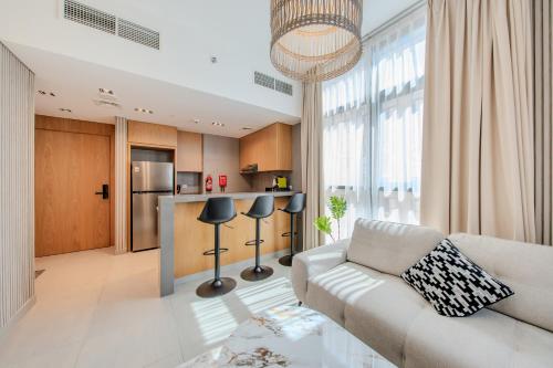 a living room with a couch and a kitchen at 1BR The Golden Souq by Blue Cloud Holidays in Sharjah Intl